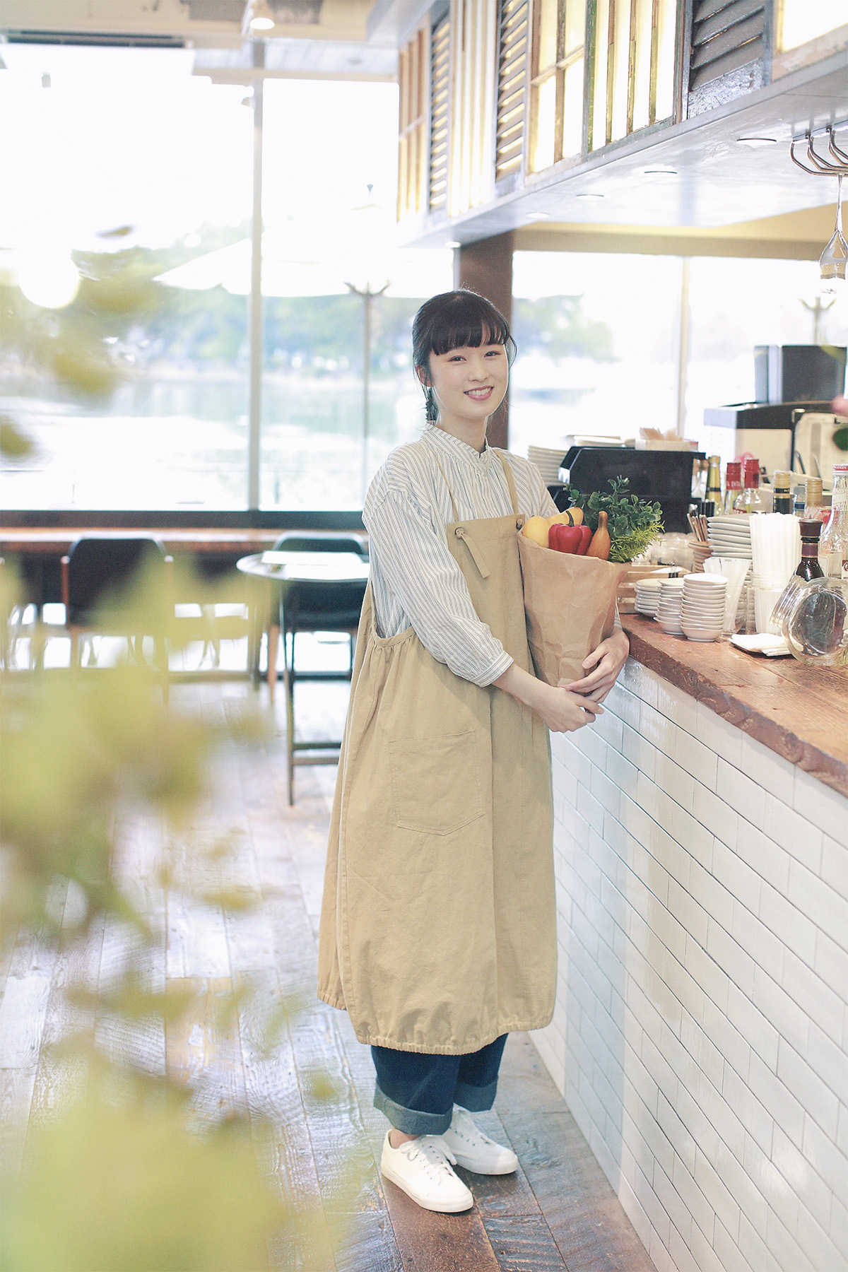 エプロンとストライプシャツの女性モデル写真