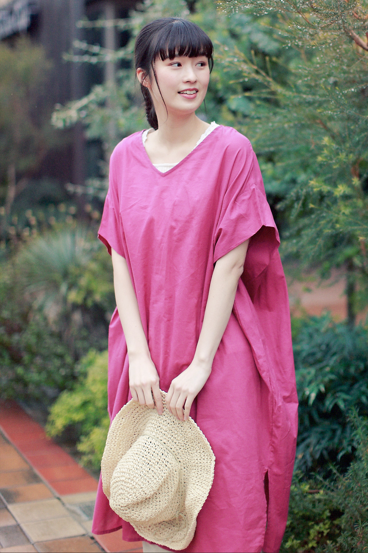 ピンクのワンピースに麦わら帽子のコーディネートの女性モデル写真