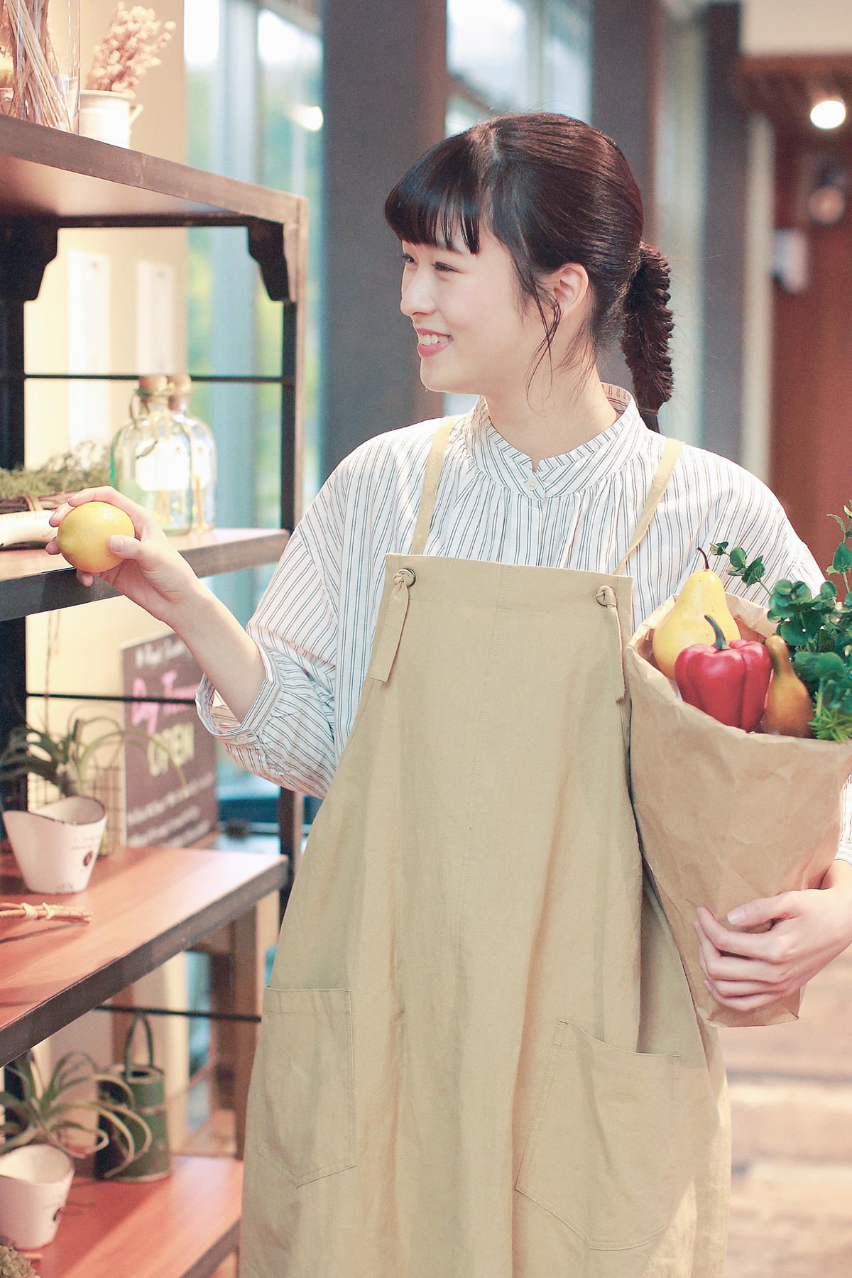 エプロンとストライプシャツの女性モデル写真