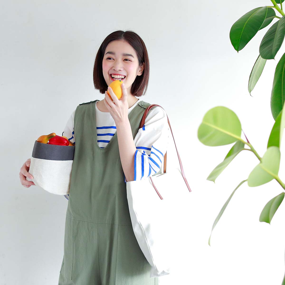 カーキのオールインワンとのボーダーのカットソーのコーディネートの女性モデル写真