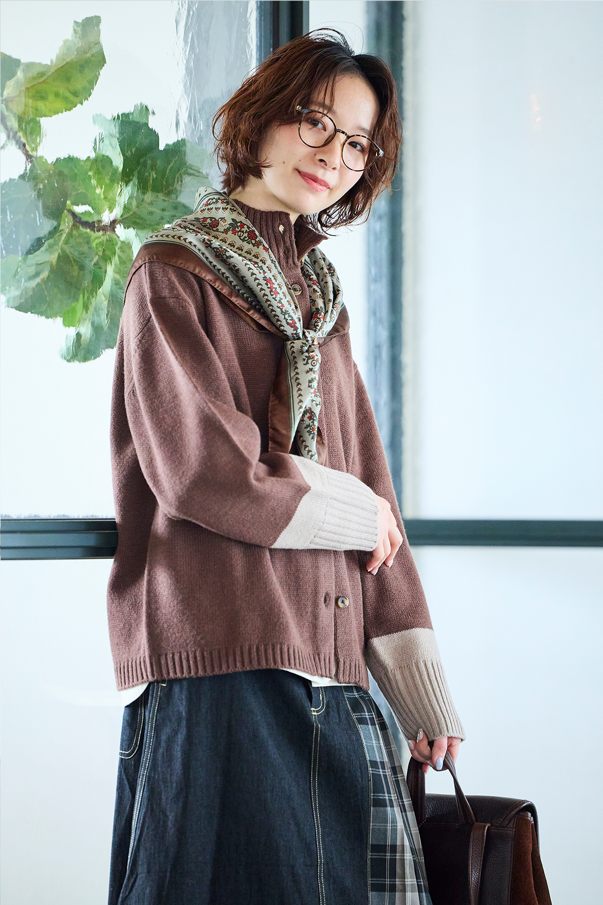 ニットカーディガンとスカートを着た女性モデルの写真