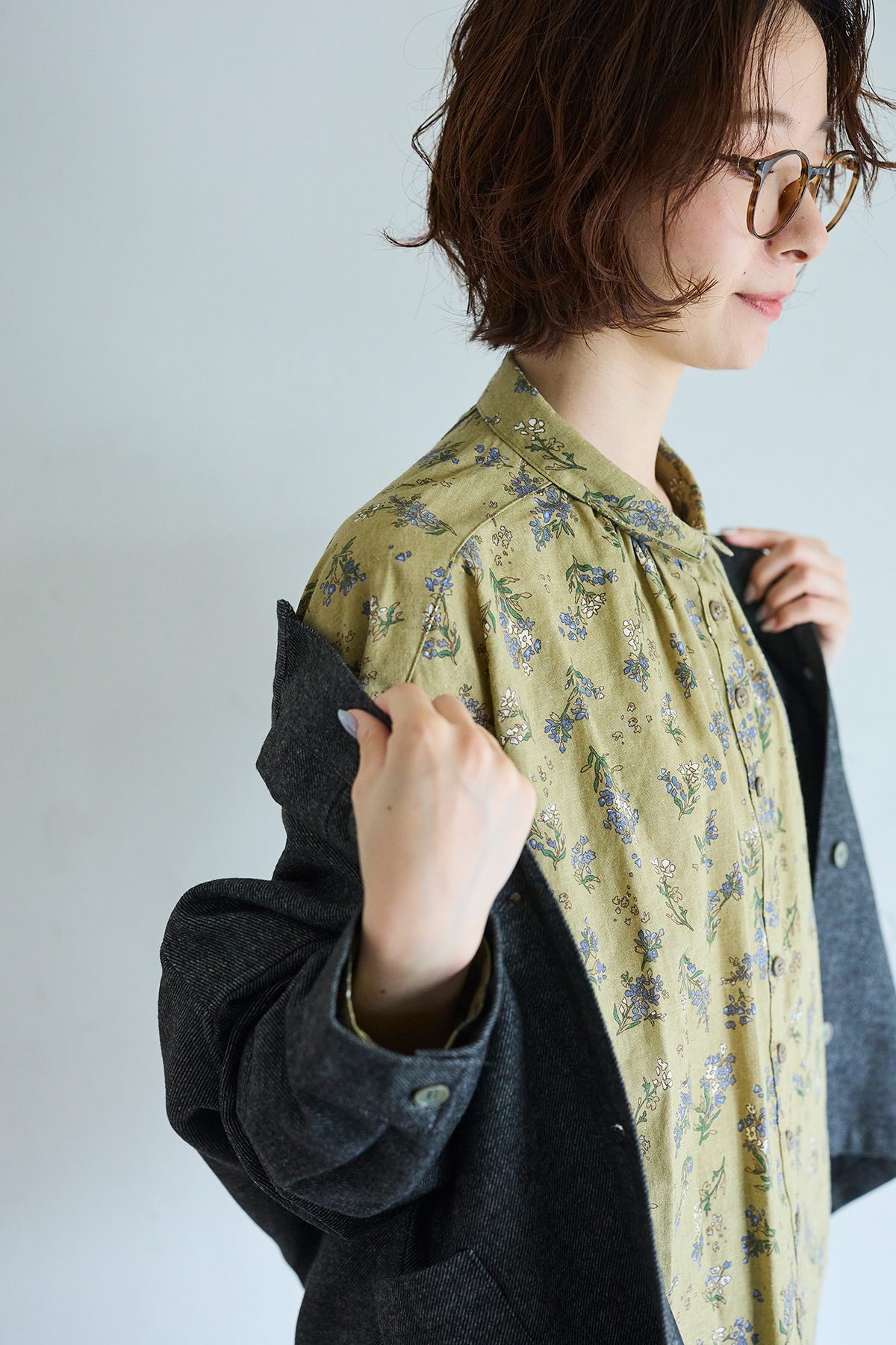 グレーのコートとパンツのセットアップを着た女性モデルの写真