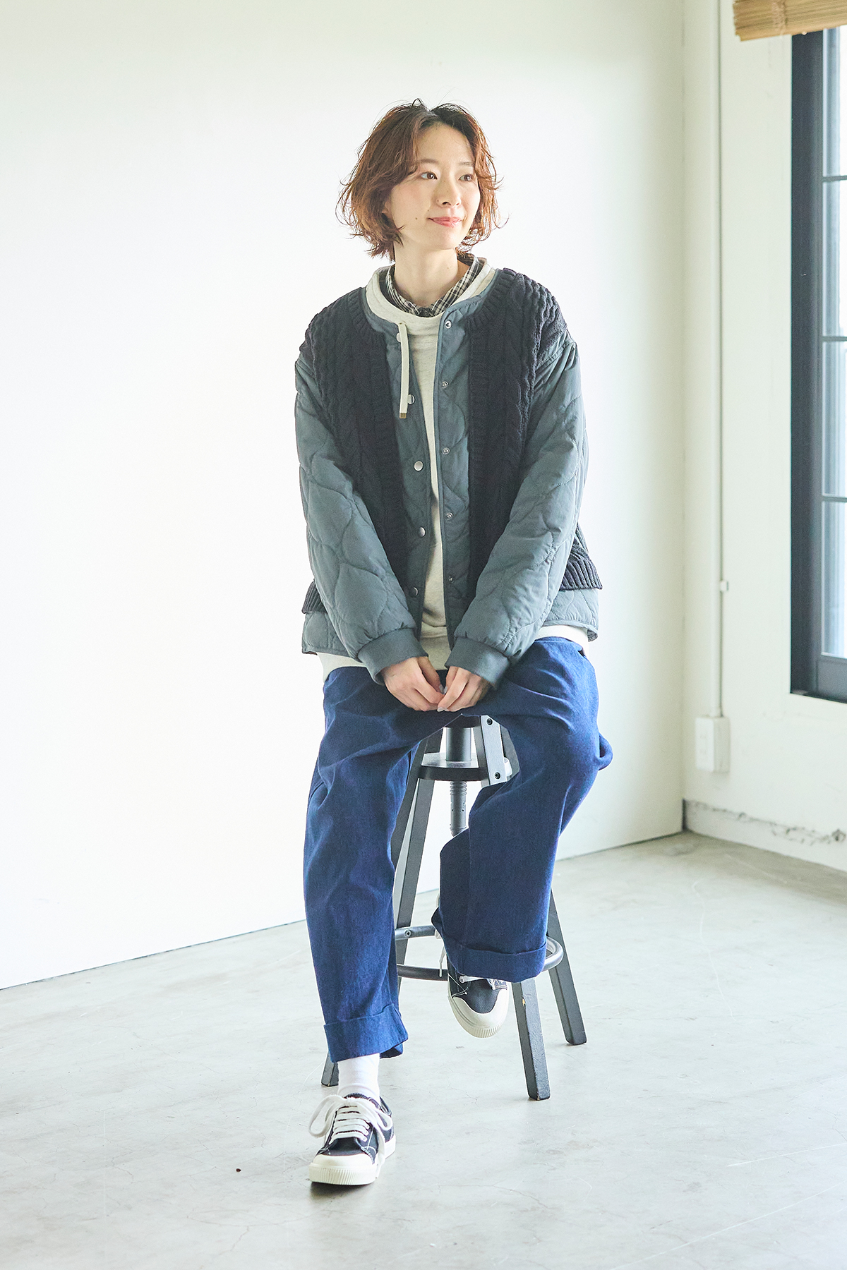 パーカーにアウターを羽織った女性モデルの写真