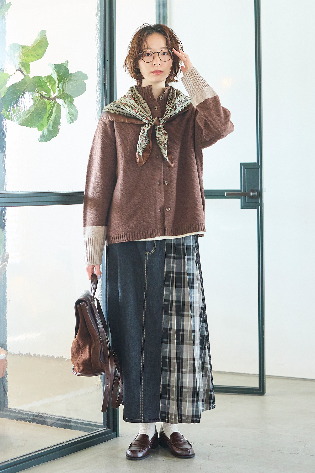 ニットカーディガンとスカートを着た女性モデルの写真