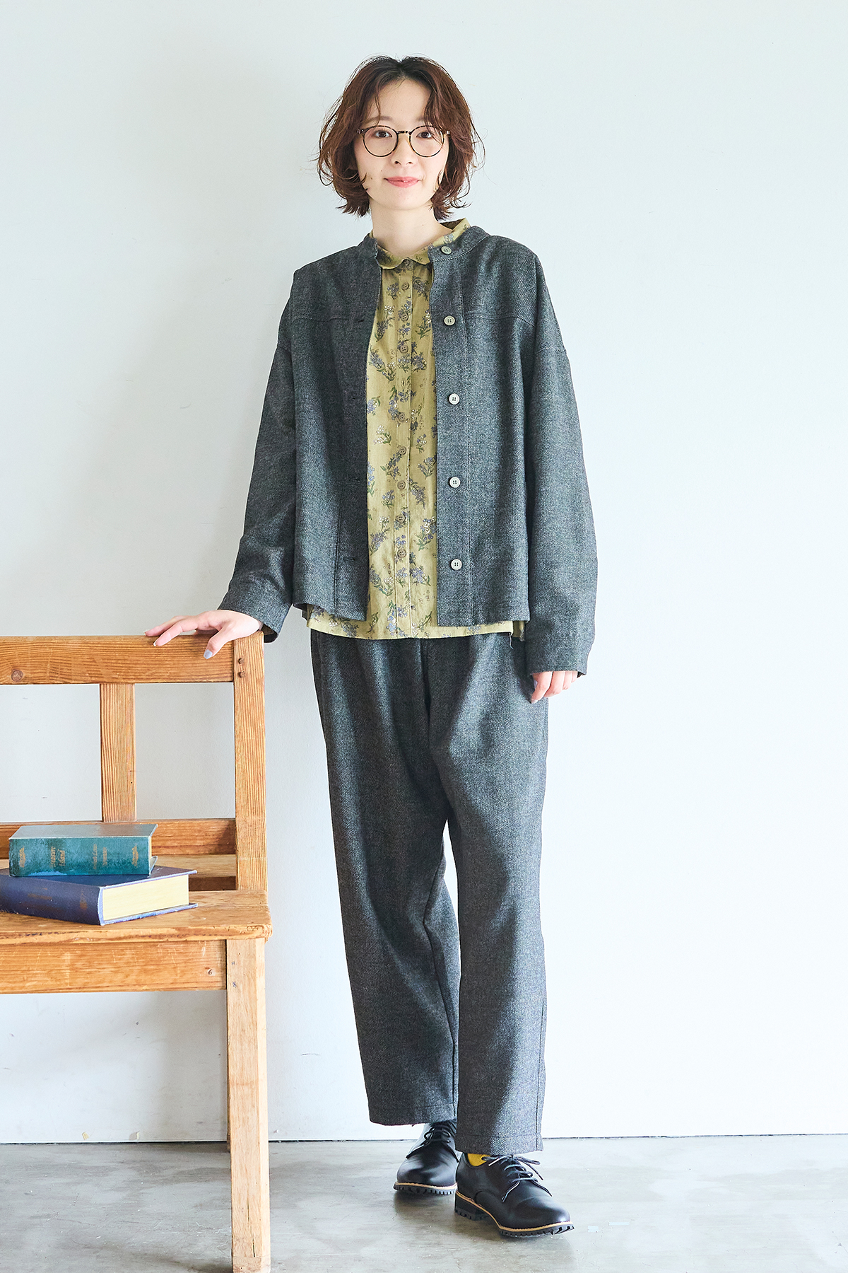 グレーのコートとパンツのセットアップを着た女性モデルの写真