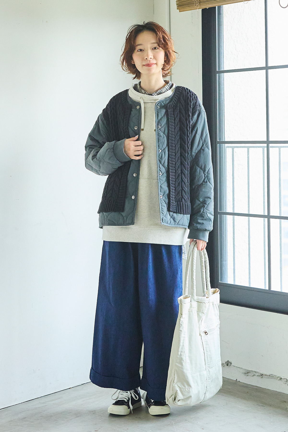 パーカーにアウターを羽織った女性モデルの写真