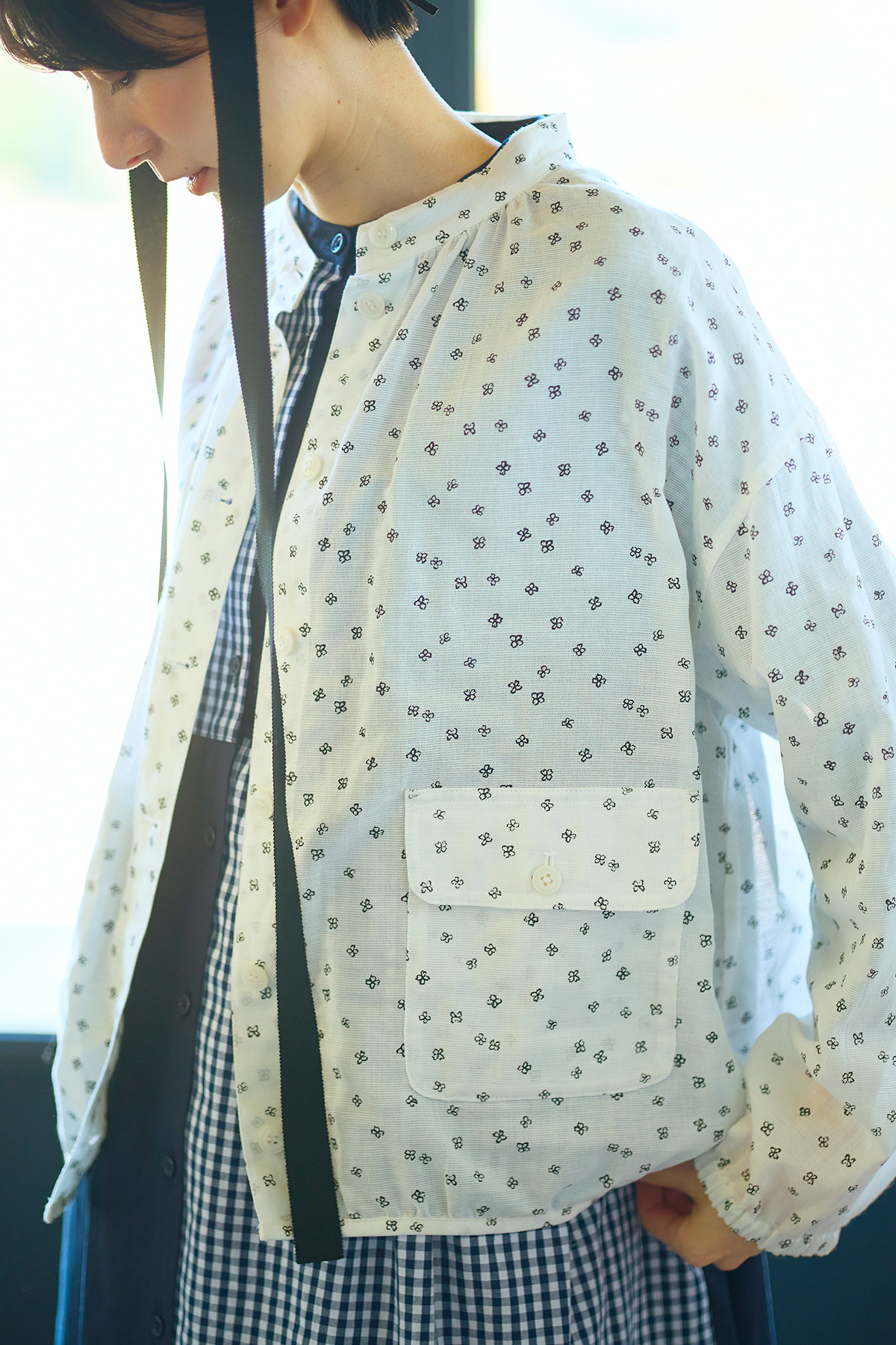 花柄のアウターを羽織った女性モデルの写真