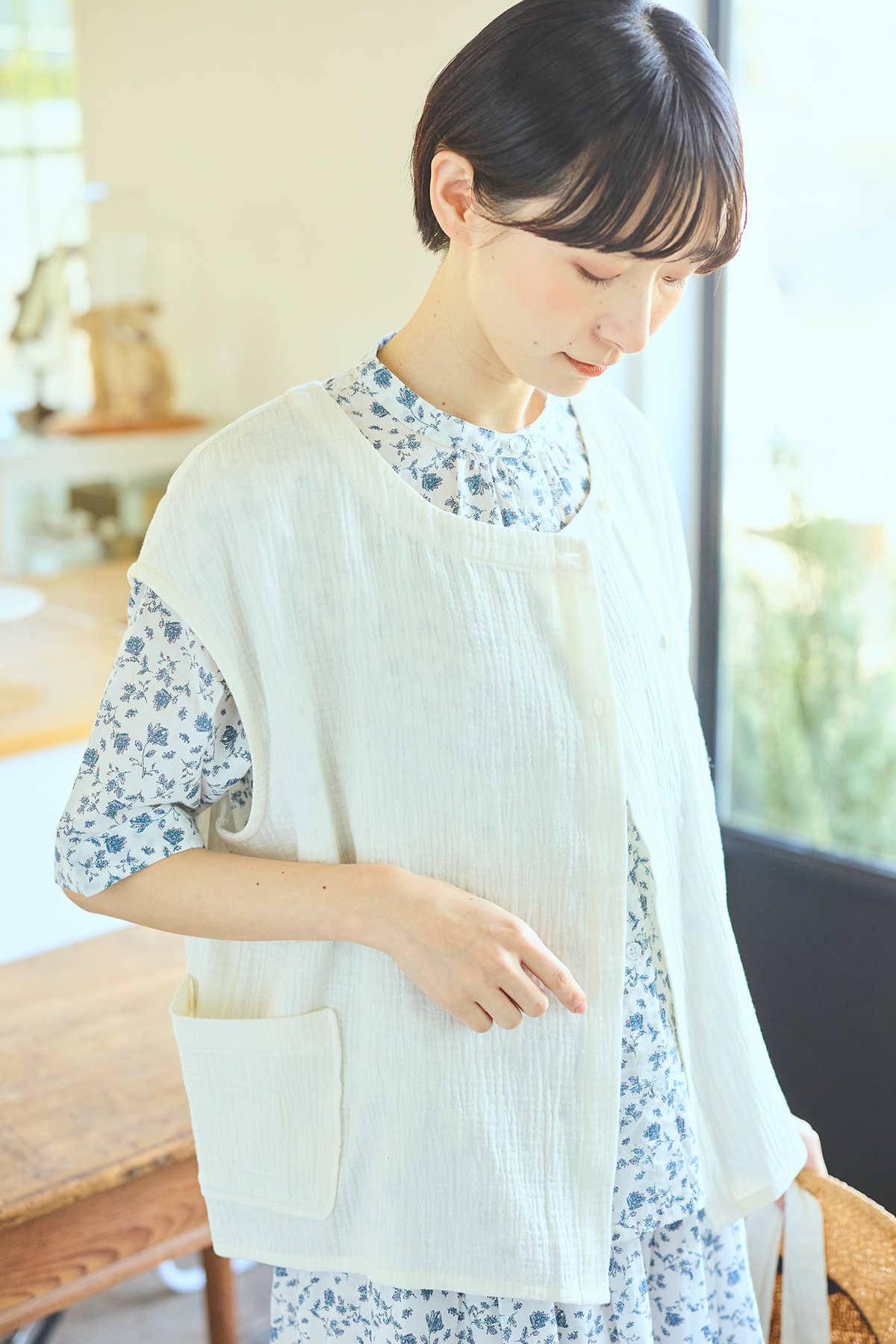 ベストと花柄のセットアップを着た女性モデル写真