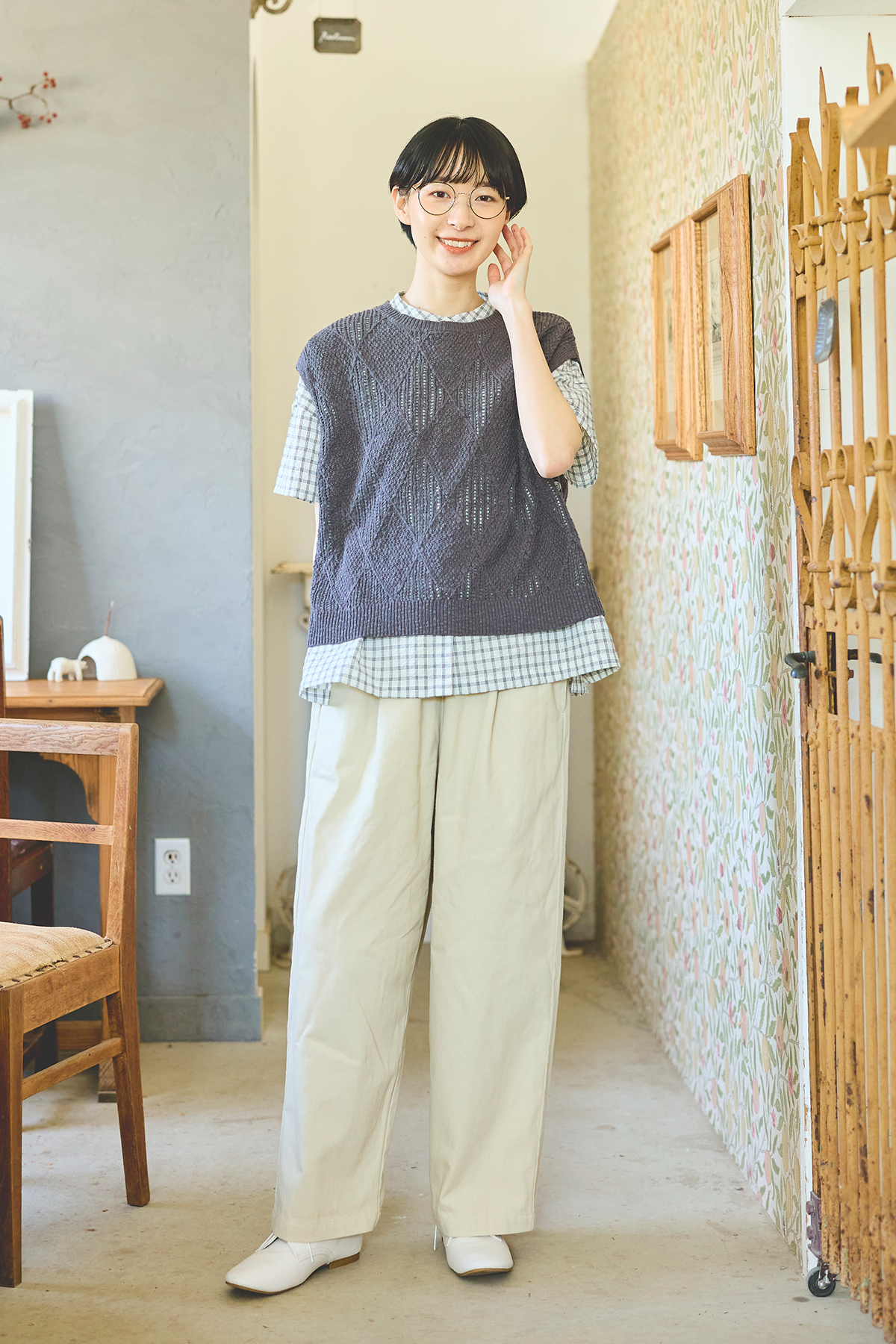 シャツとベストとパンツのコーディネートの女性モデルの写真